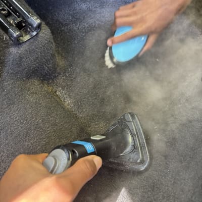Detail brush en stoomtool op tapijt